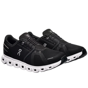 Black running shoes with white soles on a light gray background