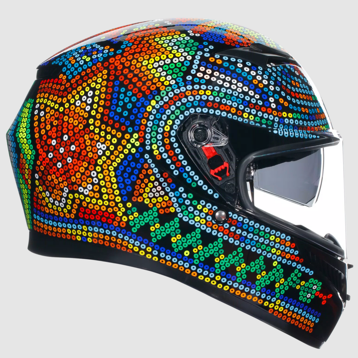 A full-face motorcycle helmet decorated with a vibrant, multicolored Aboriginal dot art pattern on a light gray background.