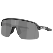 Oakley shield-style sunglasses with a matte black frame and dark gray lenses, shown on a clean light gray background with a faint reflection below.