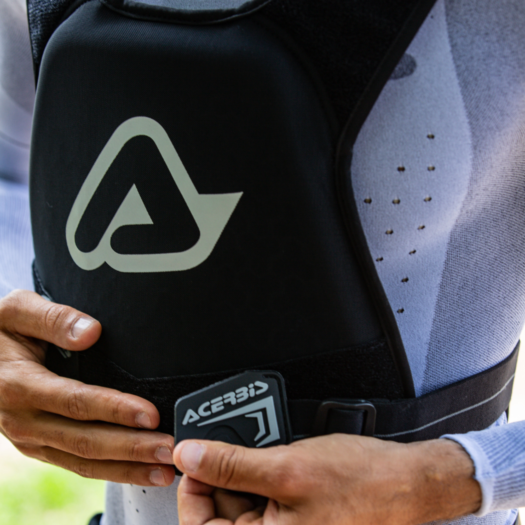 Person wearing a black Acerbis protective vest with a logo.