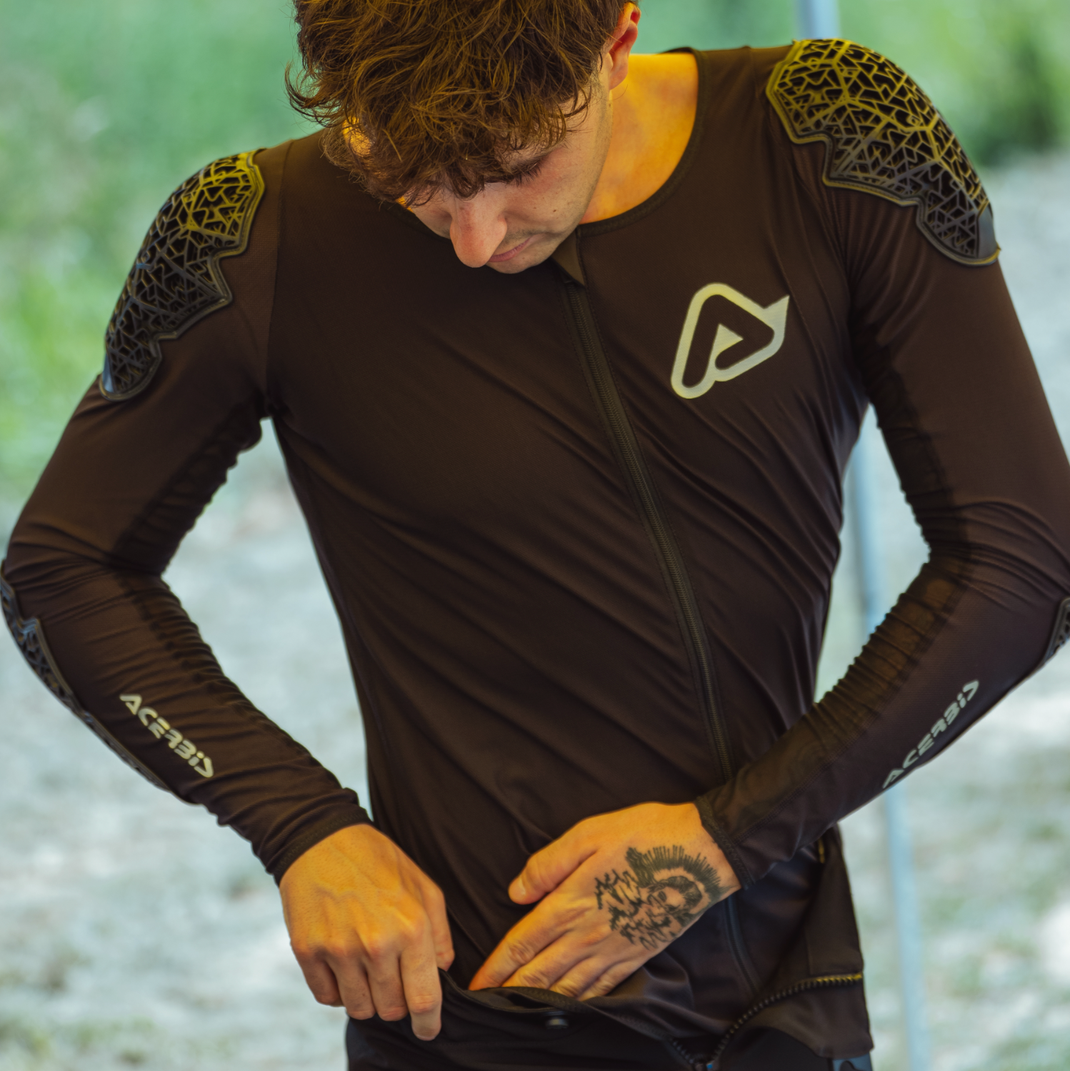 Person wearing a brown athletic outfit with shoulder pads outdoors