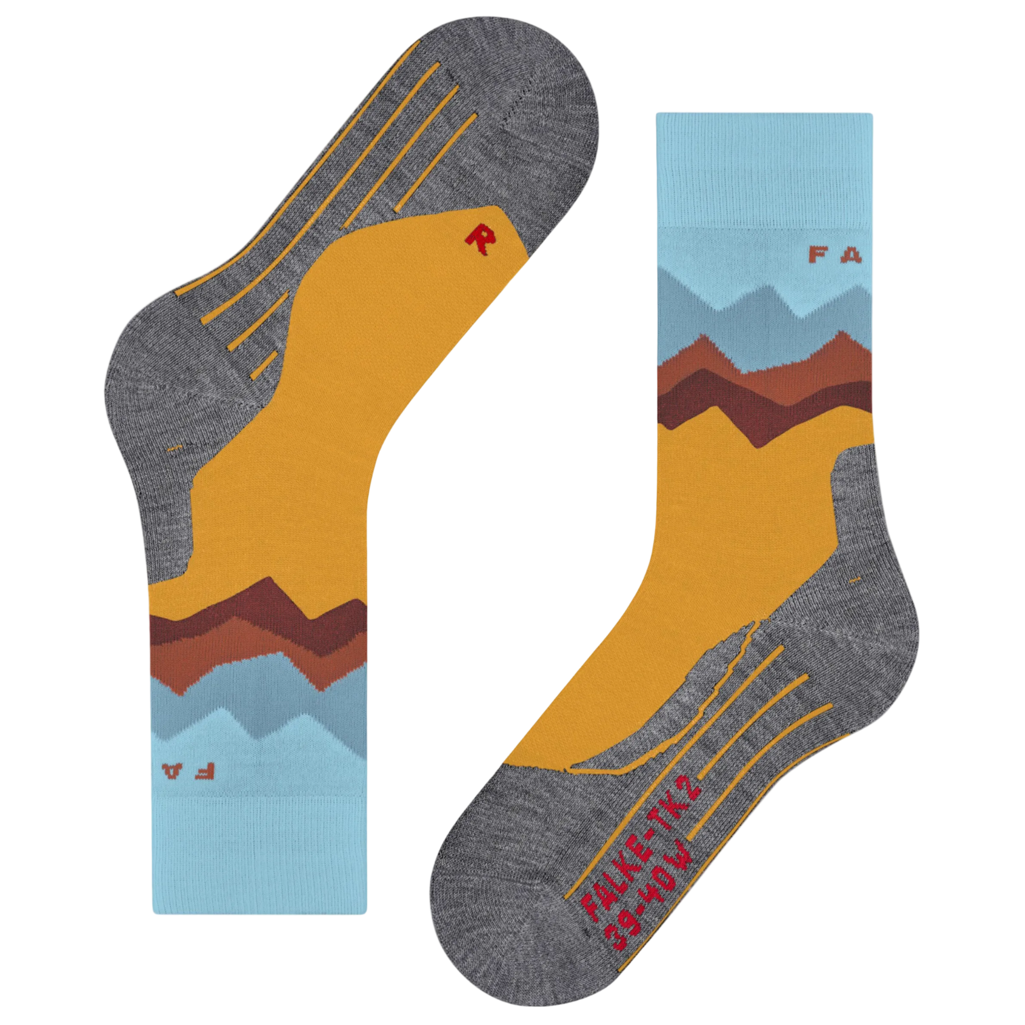 A pair of crew socks shown flat on a white background, featuring a mountain landscape design with a mustard yellow field, brown and red peaks, light blue sky layers, and heather gray toe/heel areas with yellow line details.
