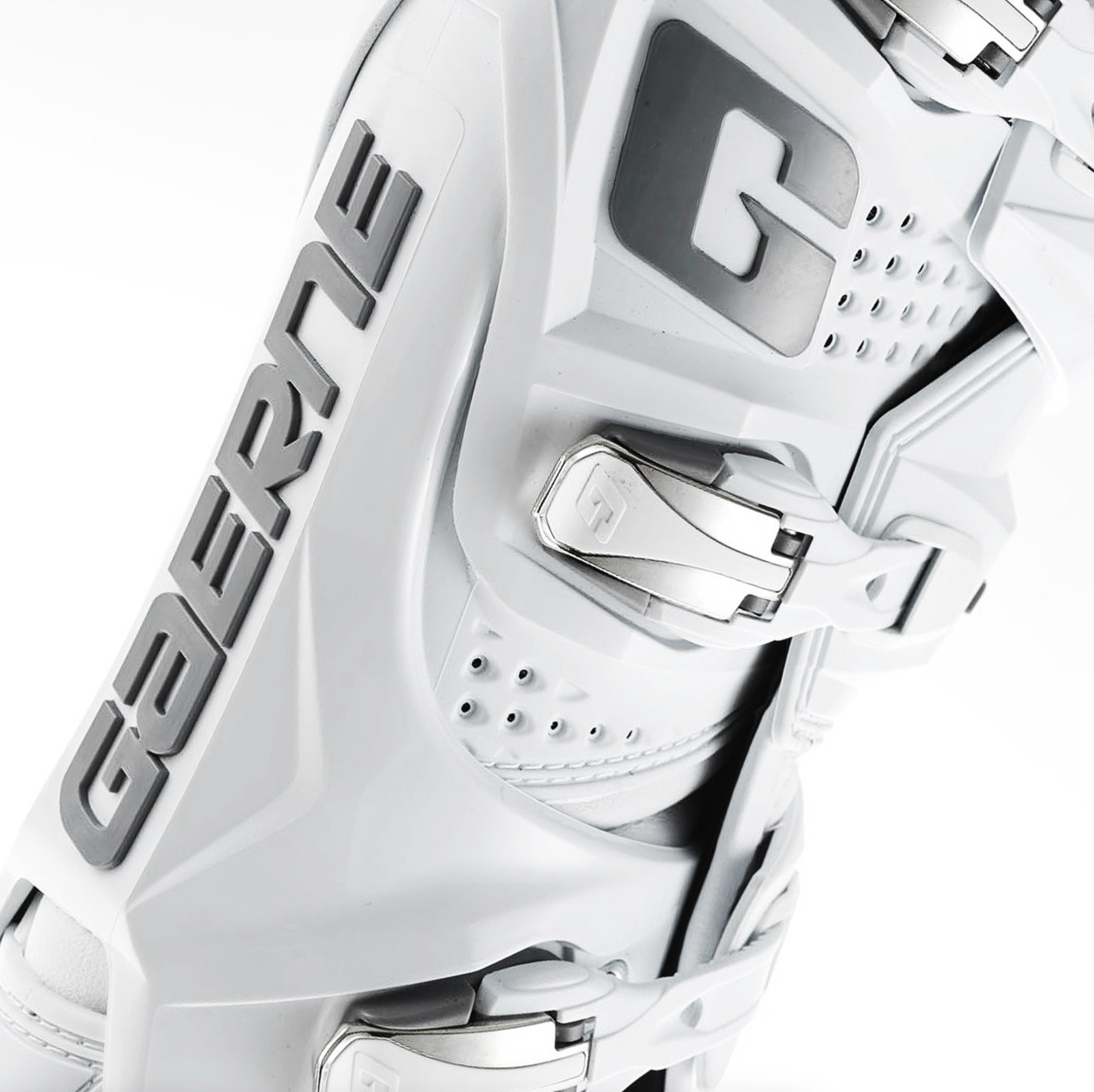 A close-up of a white ski boot with gray branding and silver buckle hardware, photographed on a clean white background.
